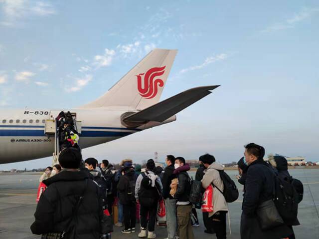 3月4日，从乌克兰转移到罗马尼亚布加勒斯特的首批中国撤侨人员排队登机。文迪/摄