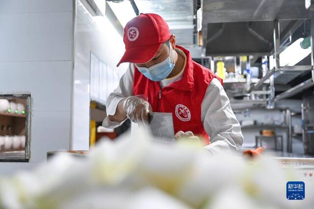 3月18日，志愿者在泉州市一家餐饮店内制作爱心午餐。