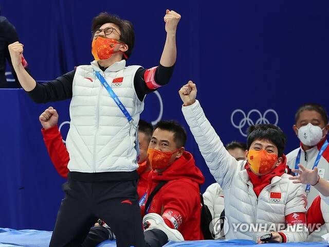 2月5日，中国短道速滑队主教练金善台（前排左一）和安贤洙（前排左二）在中国队拿下北京冬奥会短道速滑混合团体接力项目冠军后欢呼庆祝。图片来源：韩联社