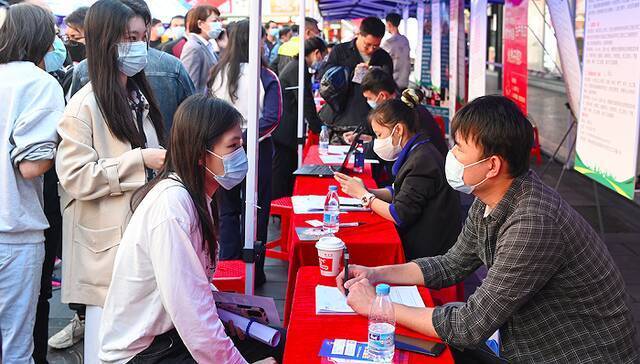 2022年2月11日，在海口市琼山区忠介路招聘会现场，求职者在应聘。图片来源：人民视觉