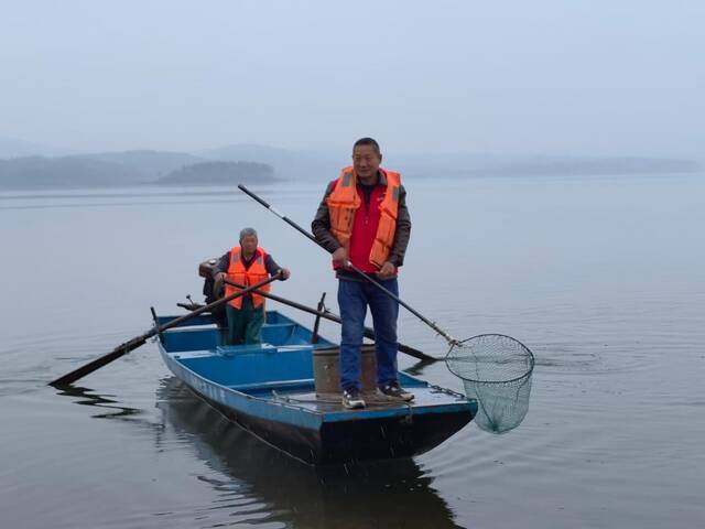 22日，罗天志（右）正在进行清漂作业。新华社记者王天宇摄