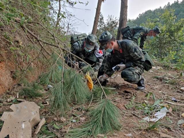 2022年3月21日，广西梧州藤县，武警广西总队梧州支队武警官兵在东航MU5735客机坠毁事故救援现场搜救清理。中新社发江怀鹏摄