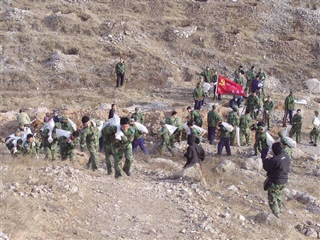 40里北山，部队官兵背土上山，支援植树造林。受访者供图