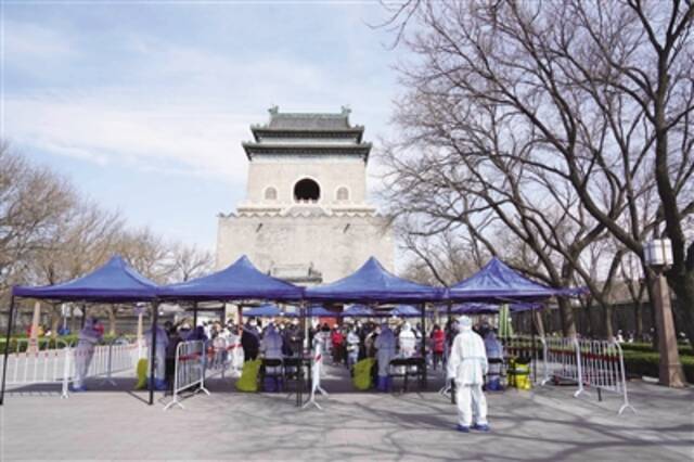 3月21日，在北京市东城区安定门街道钟鼓楼文化广场核酸采样点，医护人员为居民进行核酸采样。新华社记者鞠焕宗摄