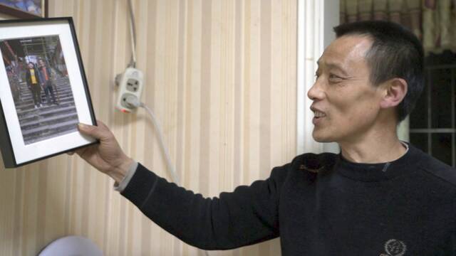 ▲2月27日晚，冉光辉展示他和儿子十年后在同一地点的合照。新京报记者戚厚磊摄