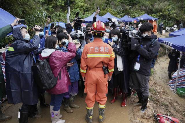 3月24日，广西梧州，一名消防战士在坠机现场附近向媒体简要介绍情况。