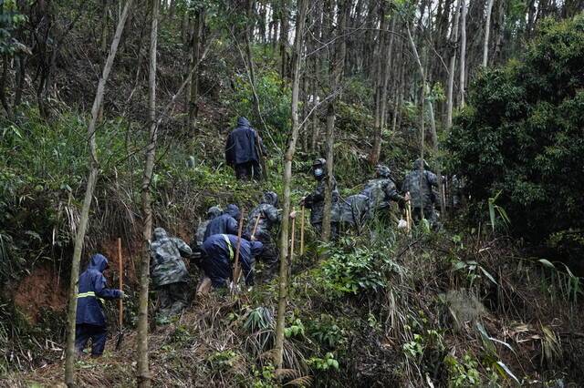 3月24日，广西梧州，消防战士官兵们扛着铁锹前往客机失事地点搜寻黑第二部匣子。