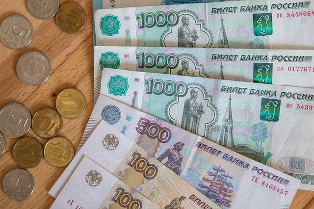 ↑这是3月24日在俄罗斯首都莫斯科拍摄的卢布钞票和硬币。新华社记者白雪骐摄