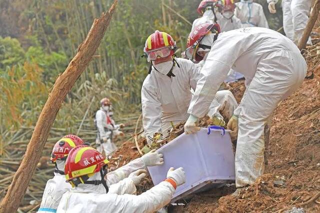 3月25日，搜救人员在事故核心现场搬运飞机残骸。新华社记者周华摄