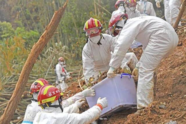 3月25日，搜救人员在事故核心现场搬运飞机残骸。新华社记者周华摄