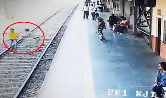 印度一少年跳下站台 警察冲过去将其推走避开火车撞击