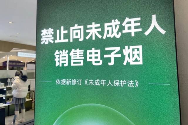 资料图。北京一家电子烟雾化器专卖店贴出的的警示牌。图据视觉中国