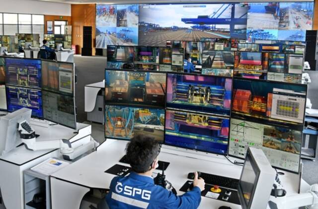 3月24日，操作人员在山东港口青岛港全自动化集装箱码头控制室内监控作业。新华社照片
