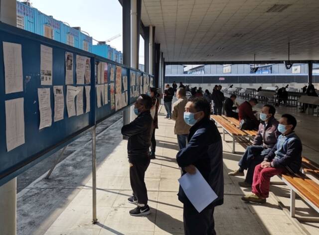2022年3月23日，在成都市锦江区人力资源市场，农民工正在浏览招工信息。新华社记者陈健摄