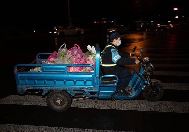 在上海市中远两湾城小区，工作人员在运输蔬菜。新华社记者金立旺摄