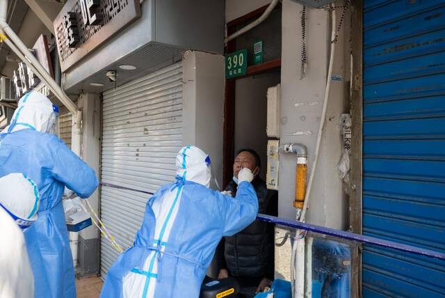 广福居委会工作人员正在给从二楼下来的张永生做抗原检测。新华社记者金立旺摄