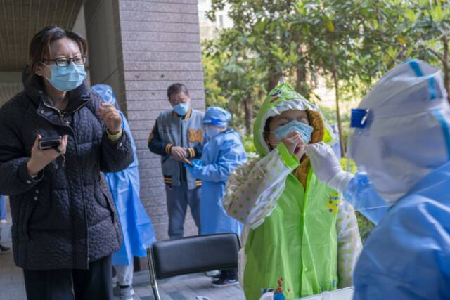 上海市普陀区某小区清晨正在楼栋前做核酸的市民