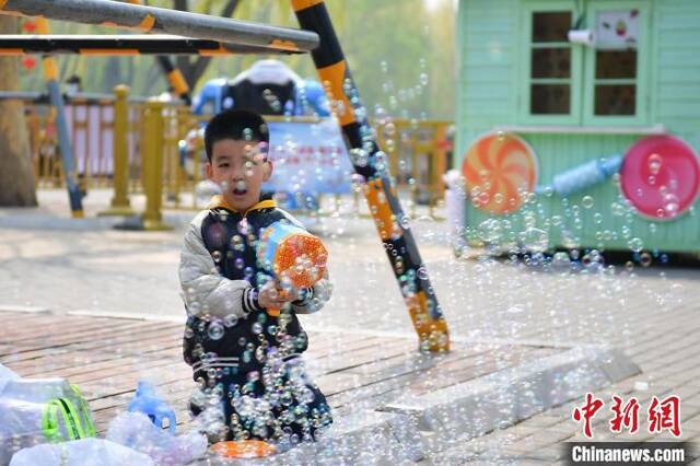 4月4日，小朋友在北京陶然亭公园玩泡泡枪。中新社记者田雨昊摄