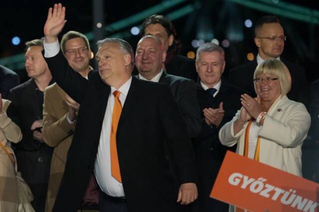 4月3日，匈牙利总理欧尔班（前）在首都布达佩斯举行的集会上向支持者挥手致意。匈牙利国家选举办公室3日晚公布的初步计票结果显示，匈牙利执政联盟（青民盟和基民党）在当天举行的国会选举中获胜。此前的4月1日，欧尔班在一次竞选集会上表示，他将保护匈牙利的国家利益，继续从俄罗斯进口天然气。弗尔季·奥蒂洛/摄（新华社发）
