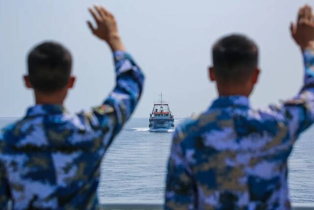 海军第40批护航编队岳阳舰为中国籍渔船护航，图为官兵向被护船舶挥手告别（胡韦楠摄）