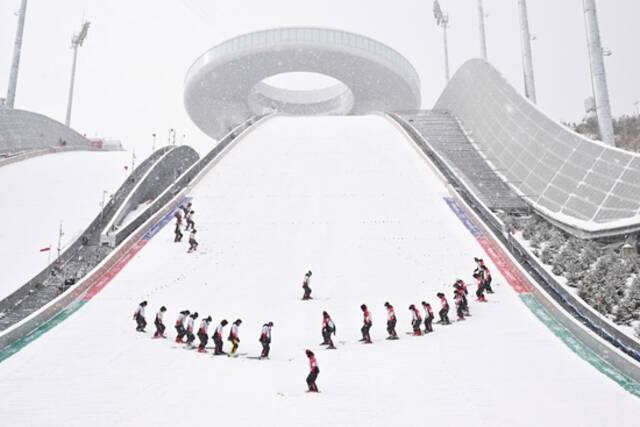 工作人员在国家跳台滑雪中心“雪如意”整理赛道。“雪如意”的设计借鉴了传统文化符号“如意”。