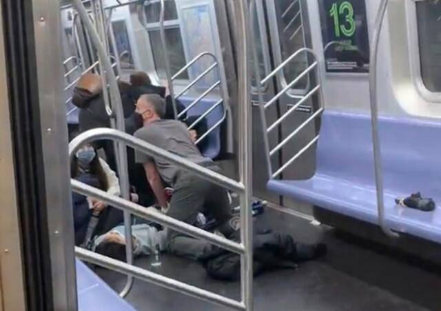 ▲枪击发生后，人们在地铁上救助受伤的人