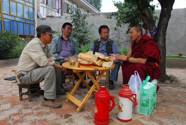 2013年7月，索南多杰（右二）在黄南藏族自治州走访当地唐卡艺人。受访者供图