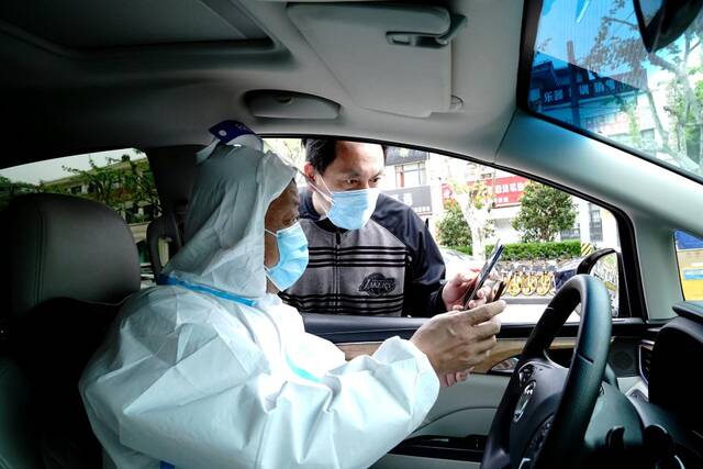 古美社区卫生服务中心家庭医生管理科负责人黄鹏宇（右）和司机冯守光（左）核对当天的任务单。新华社记者张建松摄