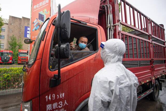 4月13日，工作人员查验驶入杭州传化公路港的货车司机健康码。新华社记者江汉摄