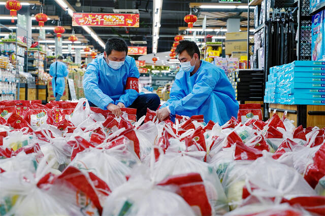 上海市奉贤区西渡街道社区发展综合服务中心的工作人员入驻超市，承担分拣配货等工作（4月17日摄）。新华社发（于薇摄）