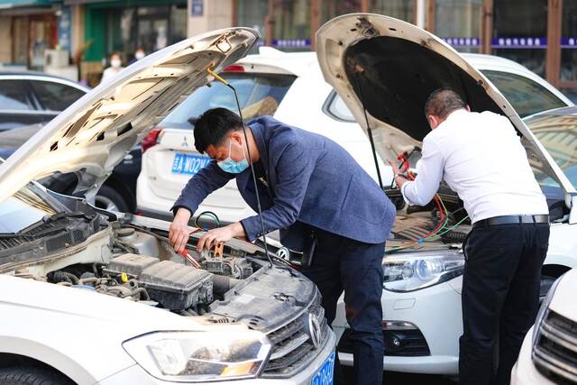 4月28日，长春市民为汽车“对火”通电。新华社记者许畅摄