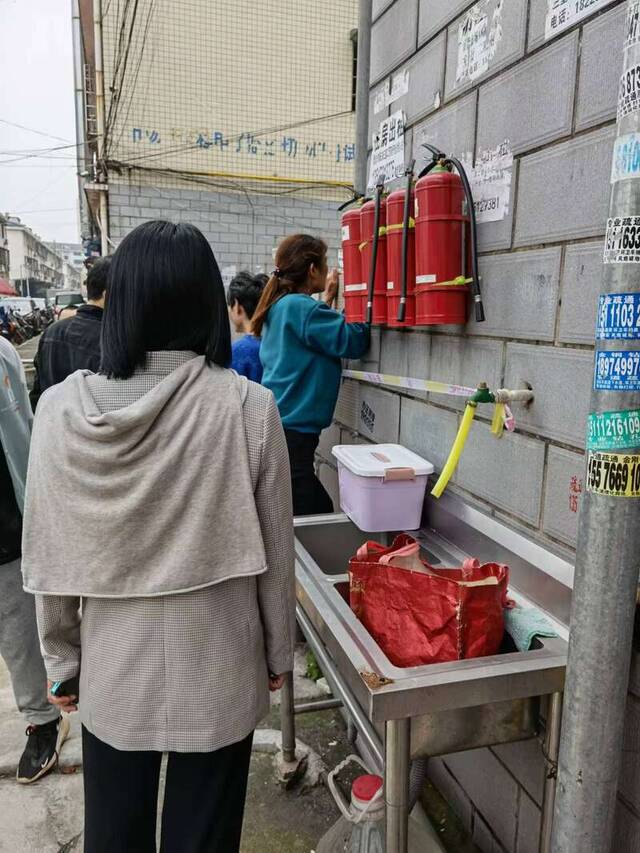 图为商业街内商铺老板设法将店内物资带出。中青报·中青网记者洪克非/摄