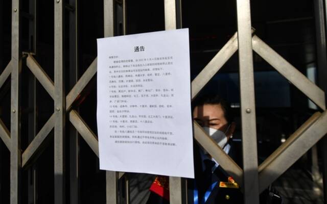 车站工作人员在门内值守，向市民解释出入口临时封闭的情况。新京报记者王贵彬摄