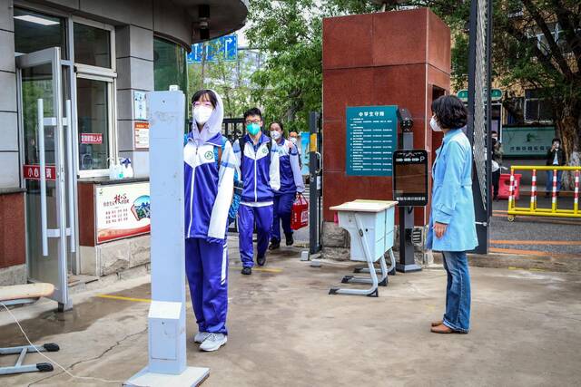 5月6日，沈阳市铁路实验中学的学生在校门口测温后进入校园。（新华社发）