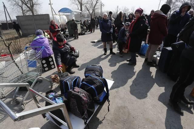 3月24日，携带行李的人们候车准备撤离马里乌波尔。新华社发（维克托摄）