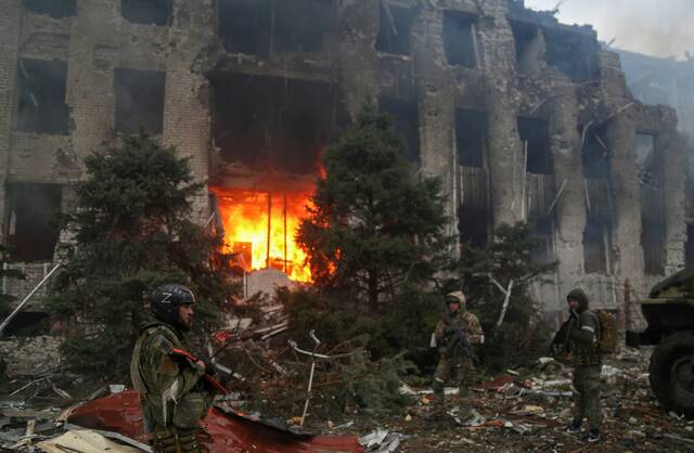 4月21日，乌克兰马里乌波尔，亲俄武装人员在亚速钢铁厂被毁的大楼前图源：澎湃影像