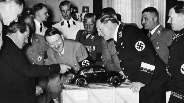 1938年，费迪南德·保时捷（最左边）向希特勒展示大众汽车模型。图片来源：英国“战争史”网站