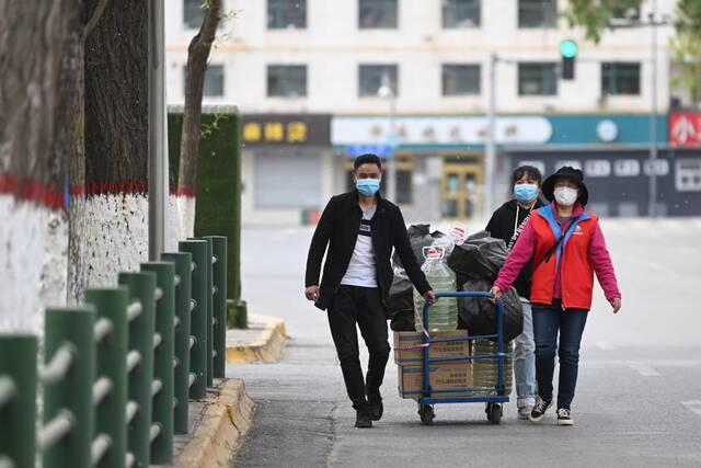 5月10日,在青海省西宁市城中区南山东社区，社区工作人员在运送防疫物资。（新华社记者张龙摄）