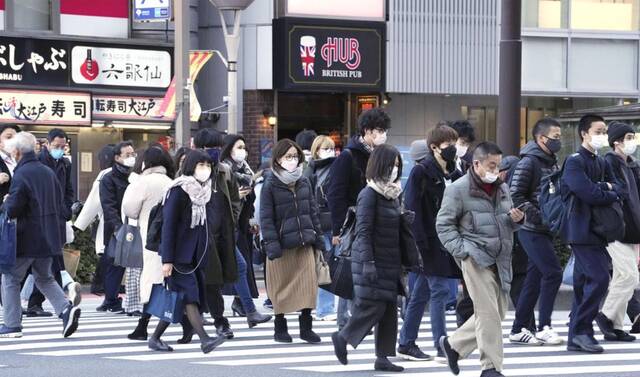 日本东京，通勤者戴着防护口罩穿梭在人行道。（资料图）