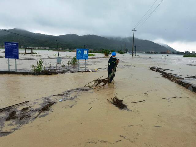 12日，台山长海桥水位超出公路，防汛干部清理杂物。（受访者供图）