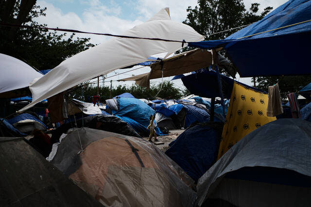 5月2日，在墨西哥雷诺萨一处移民聚集点，一名女童走过聚集点内临时搭建的帐篷。新华社记者辛悦卫摄