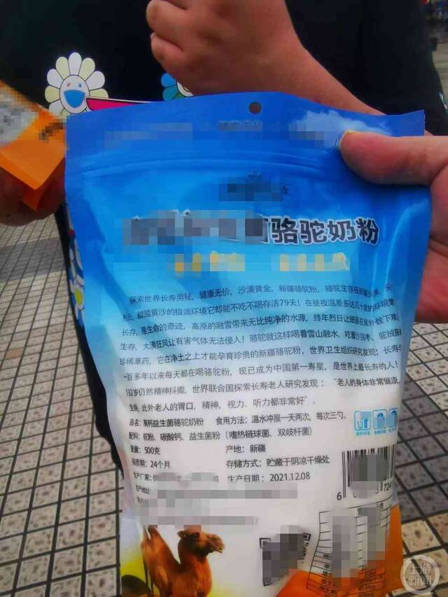 邵某及其朋友将购买的骆驼奶粉送到巴南市场监管部门进行投诉图片来源：上游新闻记者摄