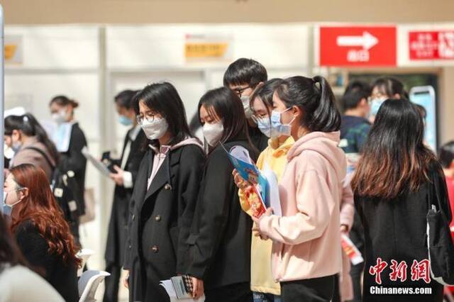 资料图：3月8日，位于江西南昌的江西财经大学蛟桥园校区，几位大学生在排队等待面试。刘力鑫摄