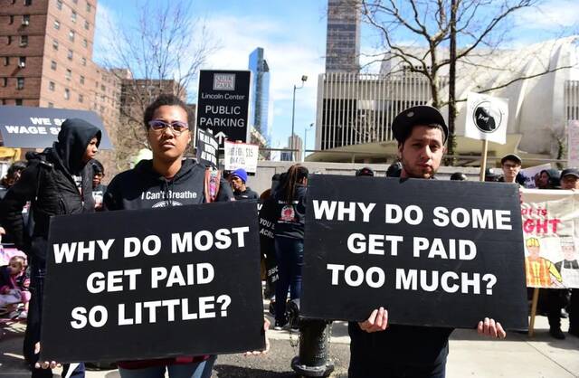 ▲纽约市民手举写着“为什么大多数人挣得那么少”“为什么有些人赚得那么多”的标语，抗议美国社会的收入不均问题。