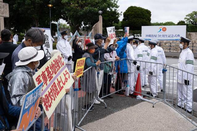  5月15日，在日本冲绳，人们在活动现场外抗议。新华社记者张笑宇摄