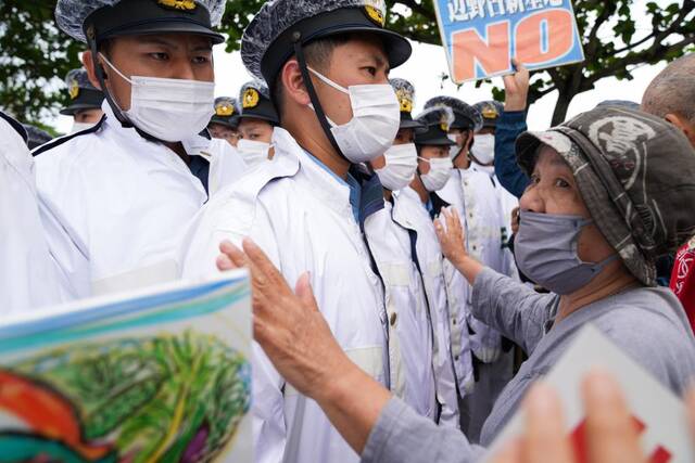 5月15日，在日本冲绳，警察在活动现场外阻拦抗议者。新华社记者张笑宇摄