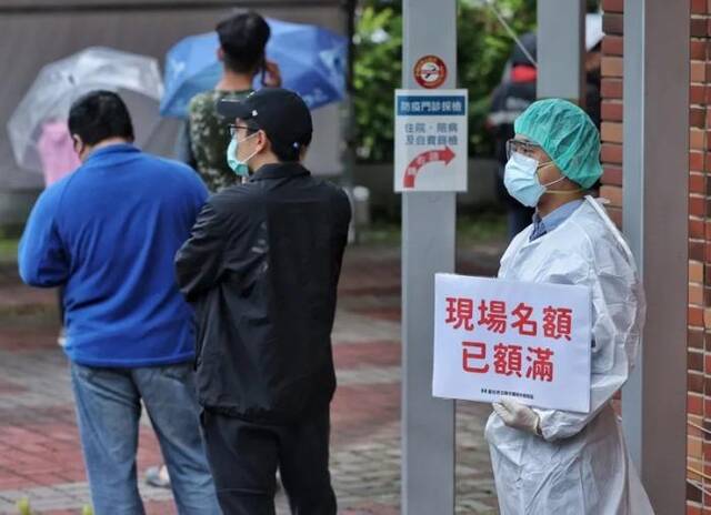 资料图：台湾快筛站现场名额额满，医护人员于排队末端举牌提醒。图片来源：台湾《联合报》，记者曾原信摄