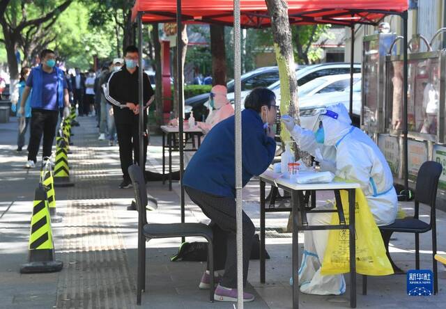 5月16日，在北京市海淀区中关村街道东里南社区临时核酸检测采样点，医务人员为市民进行核酸采样。新华社记者任超摄