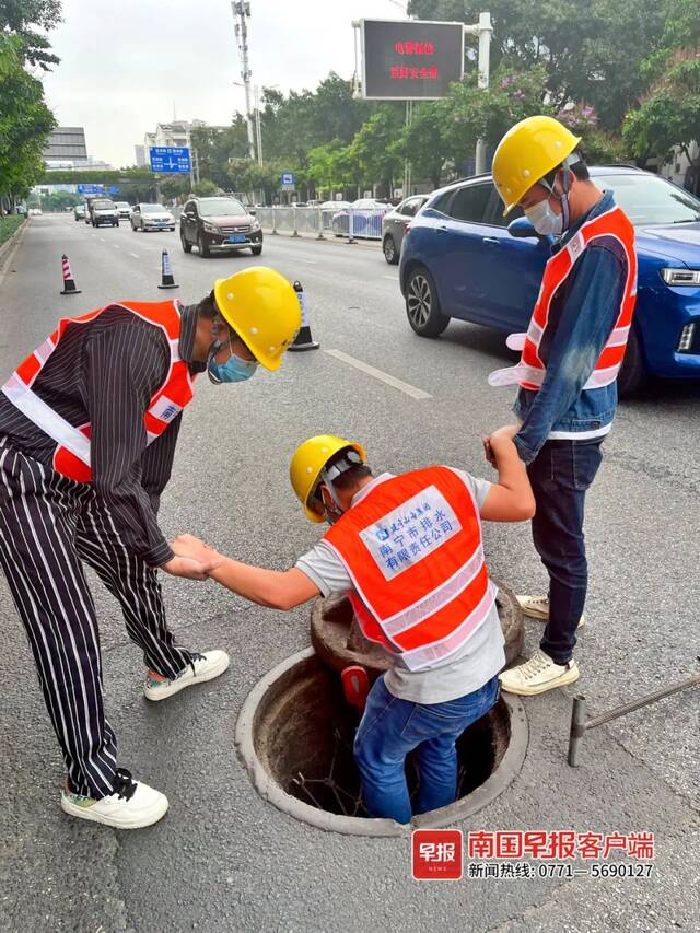 工作人员在南宁市青山路检查排水井防坠网。南国早报记者苏华摄