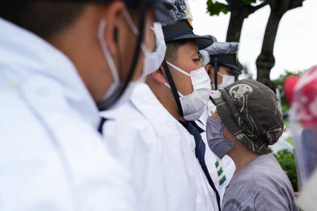 5月15日，在日本冲绳，警察在冲绳回归日本本土50周年纪念仪式现场外阻拦抗议者。新华社记者张笑宇摄